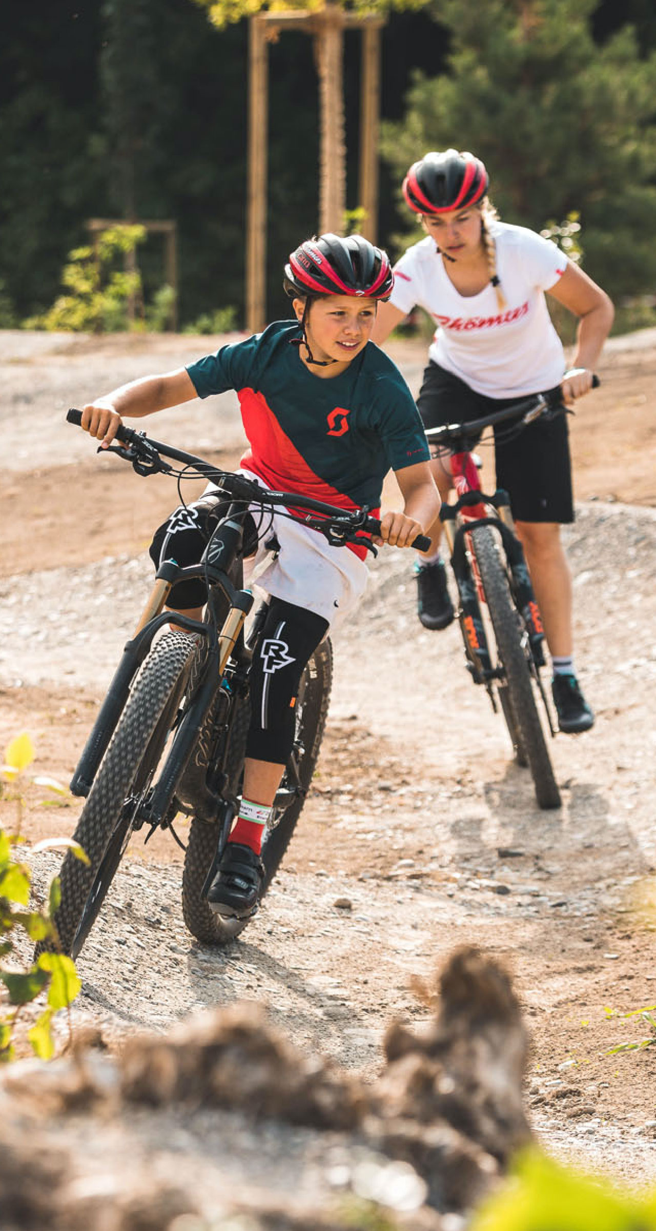 Kind wird von einem Coach beim Mountainbiken im Swiss Bike Park angeleitet
